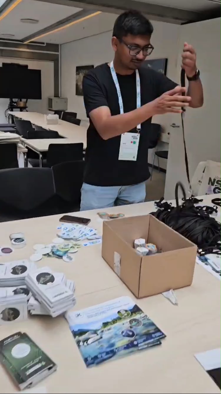 A volunteer is sorting out lanyards for the conference tags. 