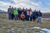 The photo shows a group of participants posing for a group photo in the countryside